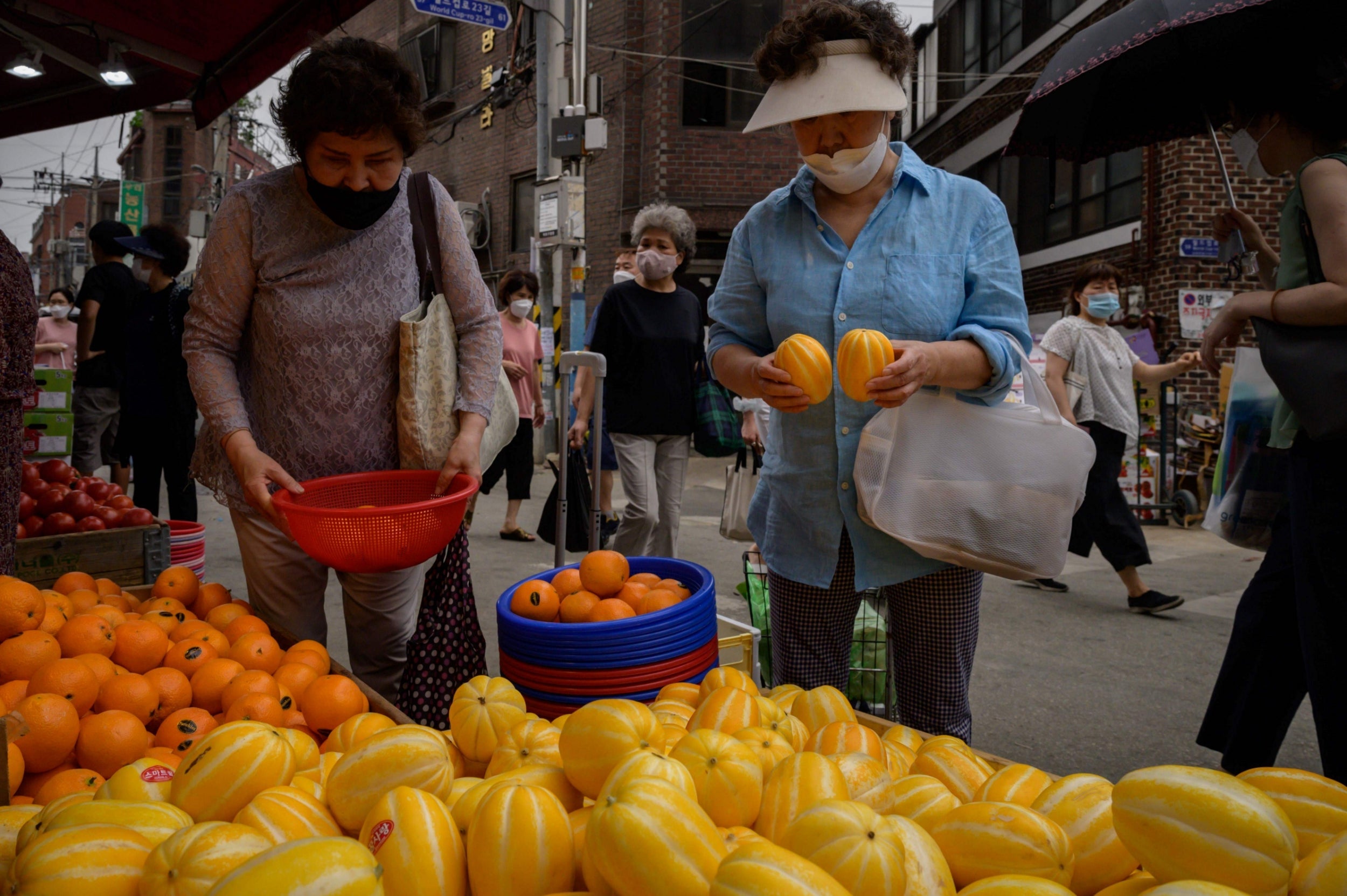 Shoppers walk through a market in Seoul