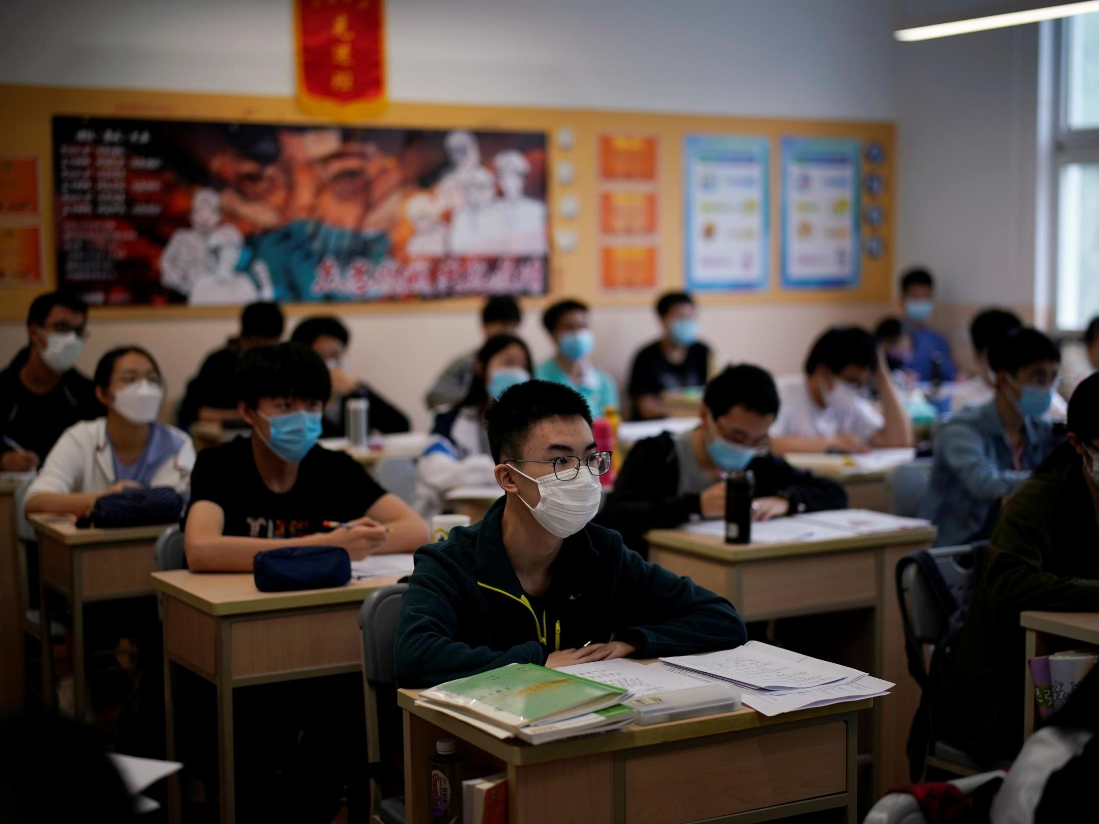 Masked students are seen inside a classroom at a high school in Shanghai