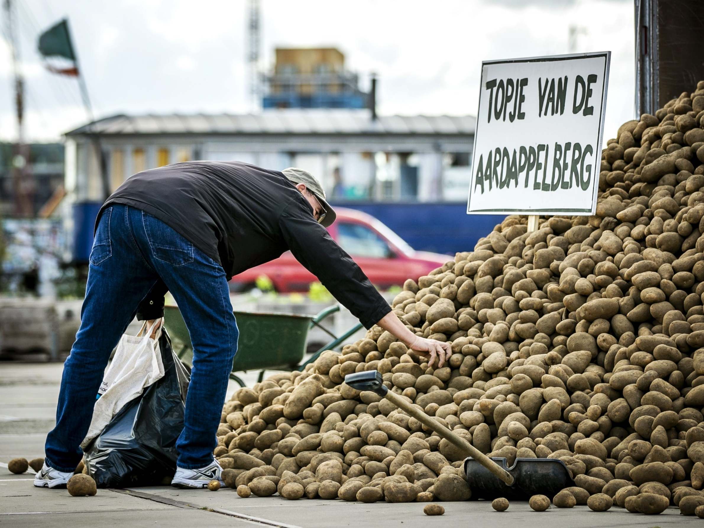 A man collects potatoes distributed for free by a lorry in Amsterdam