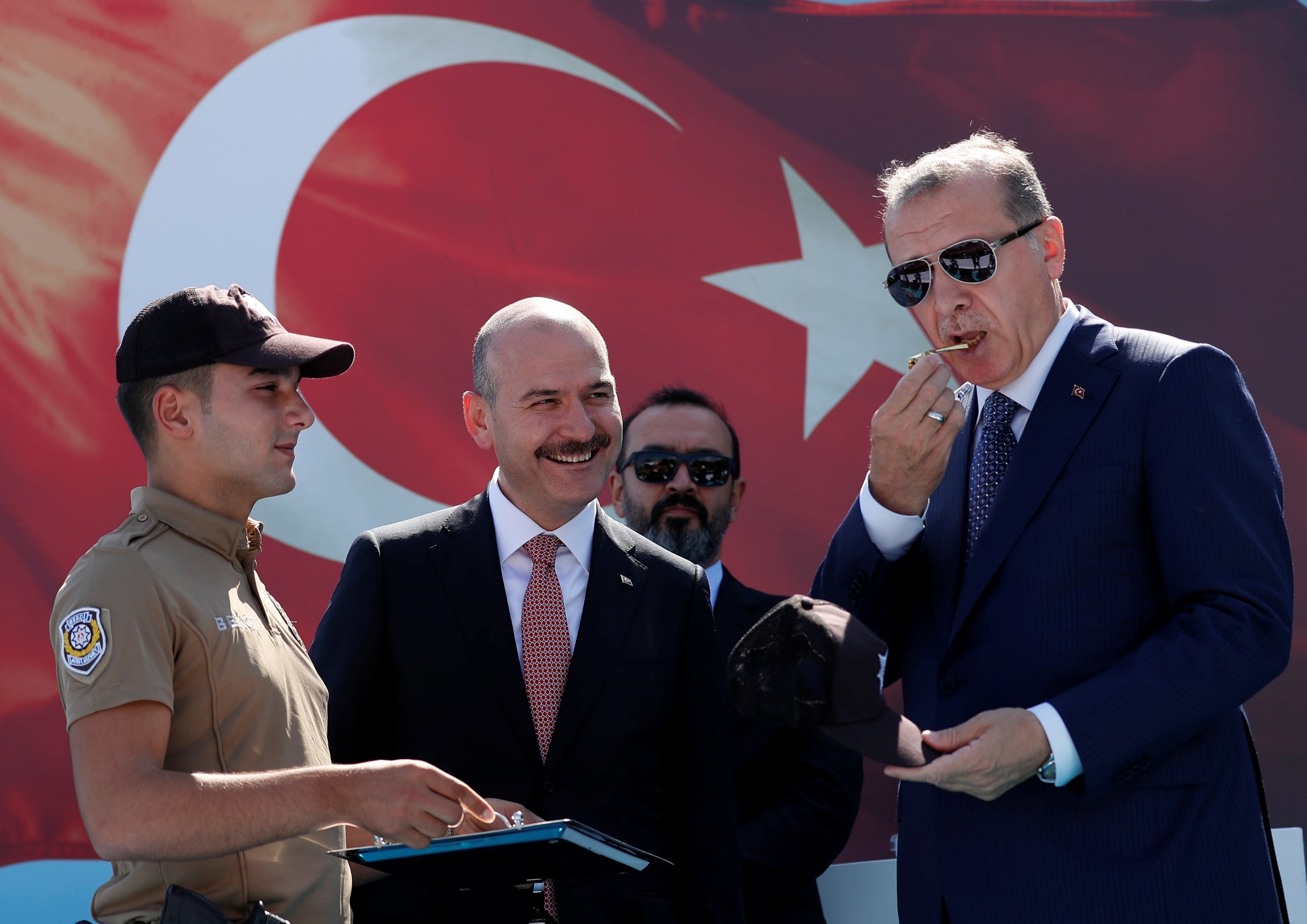 Turkish president Tayyip Erdogan, accompanied by interior minister Suleyman Soylu, blows a watchmen whistle during a ceremony in Istanbul (Reuters)
