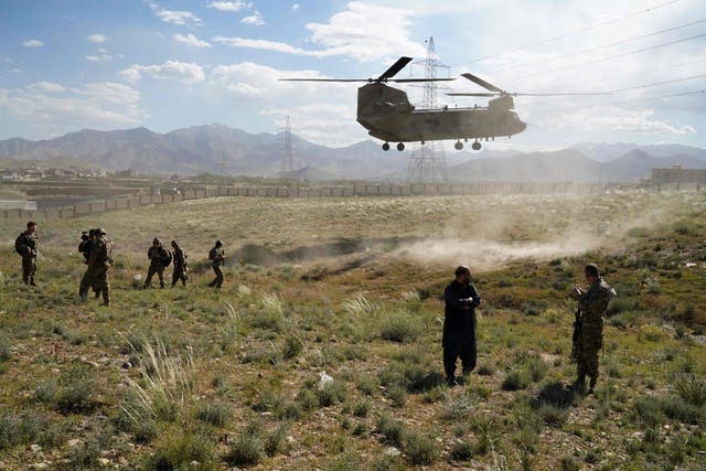 A US military Chinook helicopter lands on a field outside the governor's palace during a visit by the commander of US and NATO forces in Afghanistan, in Maidan Shar, capital of Wardak province