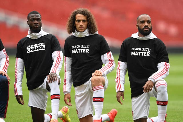 Nicolas Pepe, Matteo Guendouzi and Alexandre Lacazette of Arsenal take a knee