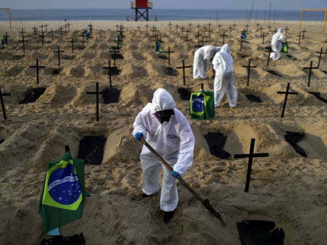 Activists of NGO Rio de Paz in protective gear dig graves on Copacabana beach to symbolise the dead from the coronavirus disease during a demonstration in Rio de Janeiro, Brazil, 11 June 2020.