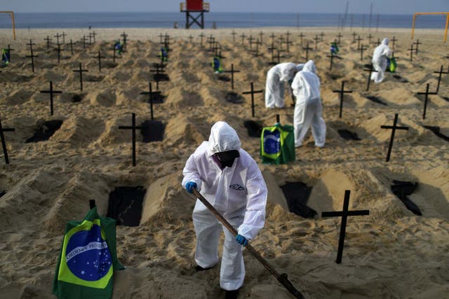 Activists of NGO Rio de Paz in protective gear dig graves on Copacabana beach to symbolise the dead from the coronavirus disease during a demonstration in Rio de Janeiro, Brazil, 11 June 2020.