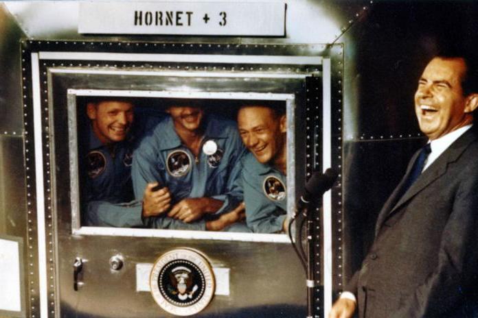 Neil Armstrong, Michael Collins and Buzz Aldrin laugh with the president Richard Nixon aboard the USS Hornet after he greeted them upon their return to Earth