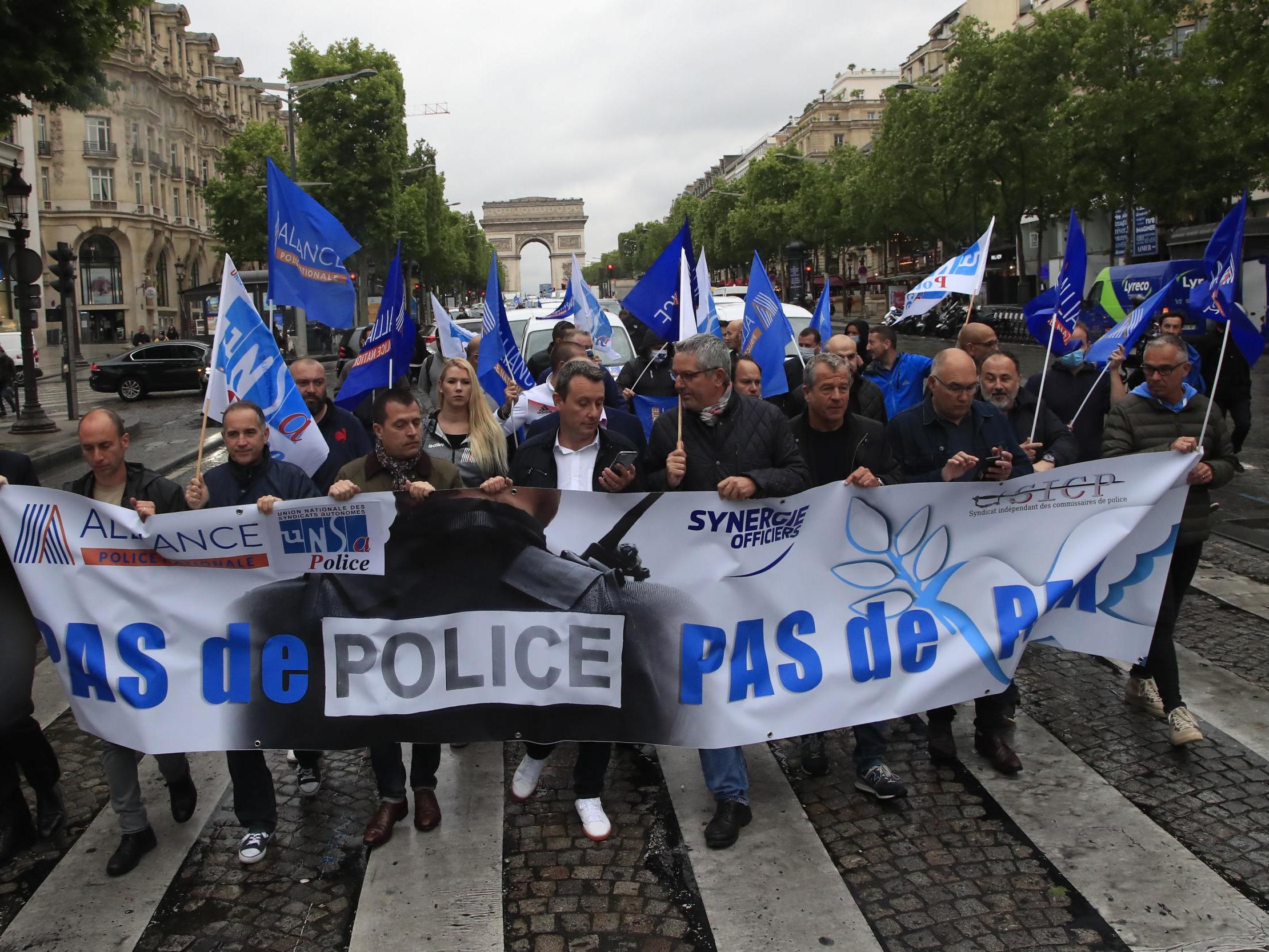 French police march down the Champs-Elysees on Friday holding a banner reading ‘no police, no peace’ (AP)