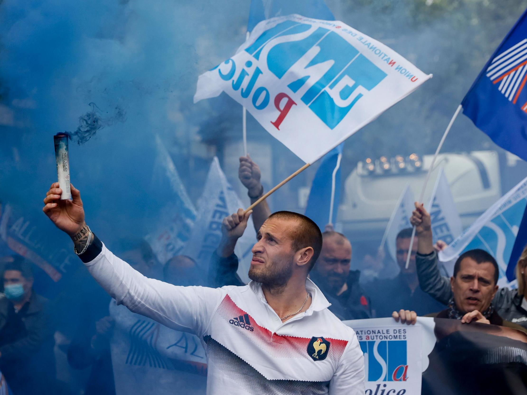 A demonstrator holds a flare during a protest of members of French police unions on Friday