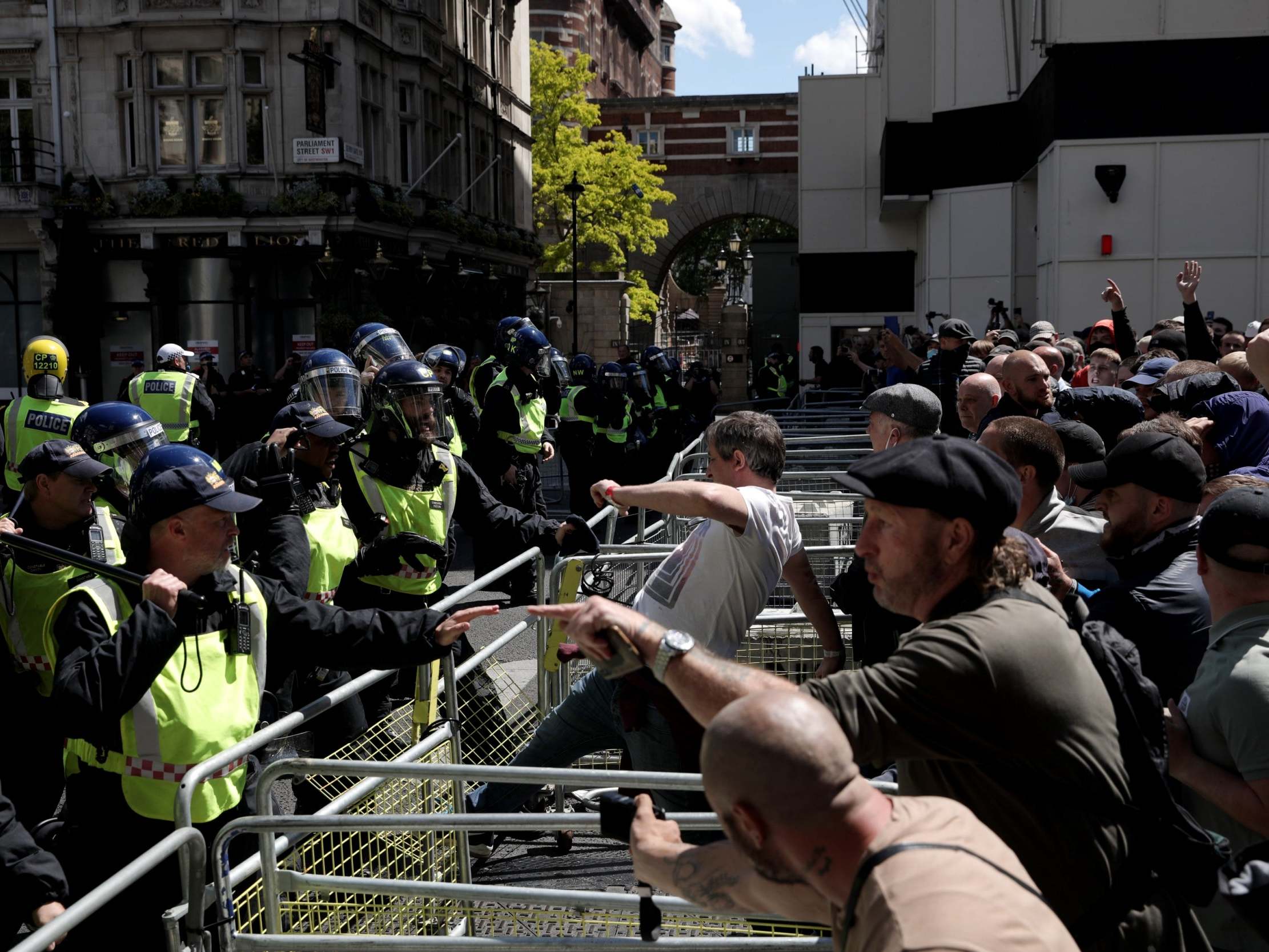 A man kicks a barrier as activists from far-right-linked groups clash with police on Parliament Street, in London, on 13 June 2020