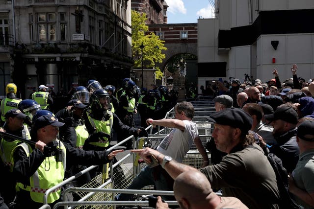A man kicks a barrier as activists from far-right-linked groups clash with police on Parliament Street, in London, on 13 June 2020