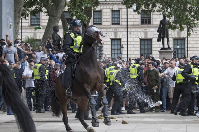 Right wing protesters hurl object at a police officer on horseback, as they clash on Parliament Square
