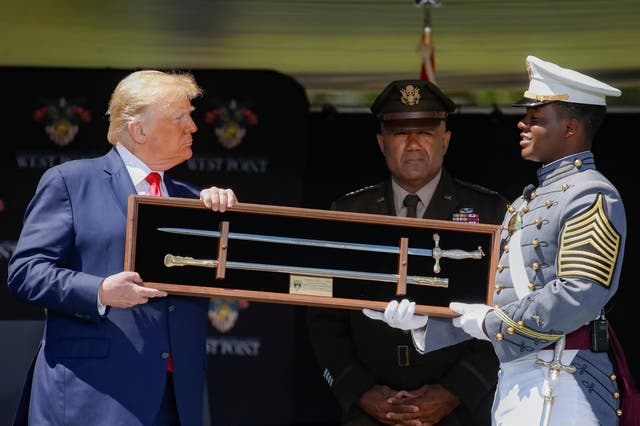 Donald Trump is offered a class gift after speaking to United States Military Academy graduating cadets during commencement ceremonies at West Point, New York