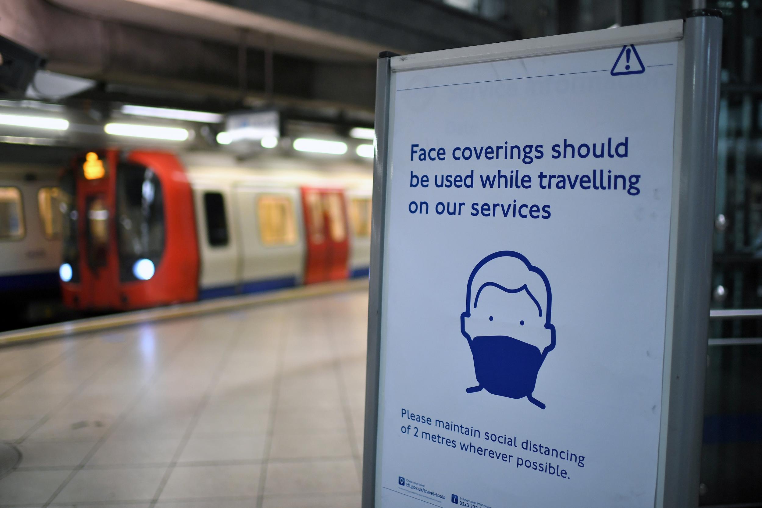 A sign tells commuters that they need to wear PPE (personal protective equipment) of a face covering, or mask, and observe social distancing as a precautionary measure against COVID-19 (Getty)