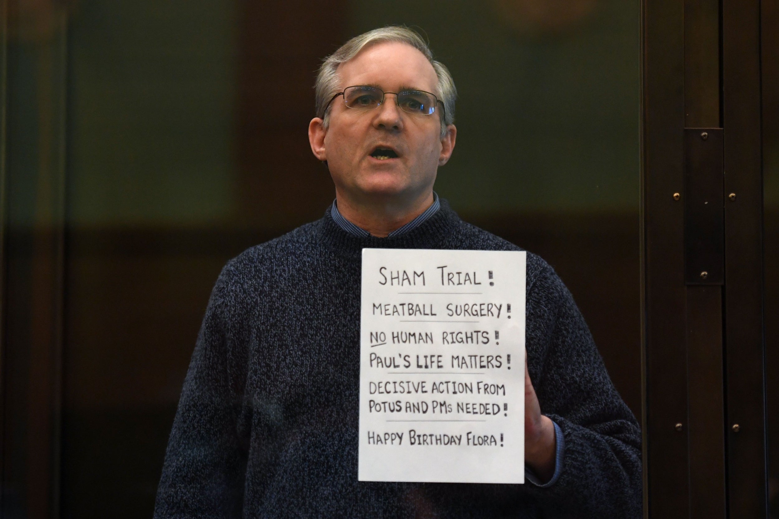 Paul Whelan holds up a message while waiting for a verdict in a Moscow court