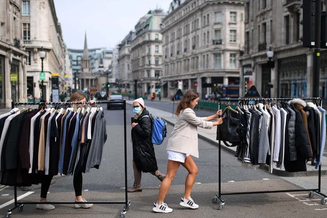 Retail workers move rails of clothes between stores on Oxford Street on 12 June