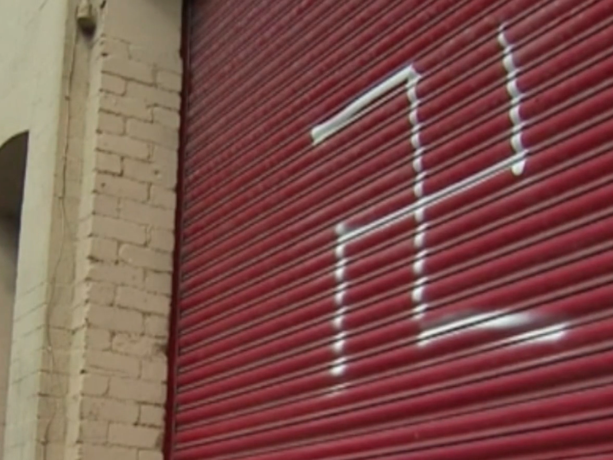 Police issue CCTV of wanted man over painting of swastika on black family's garage door