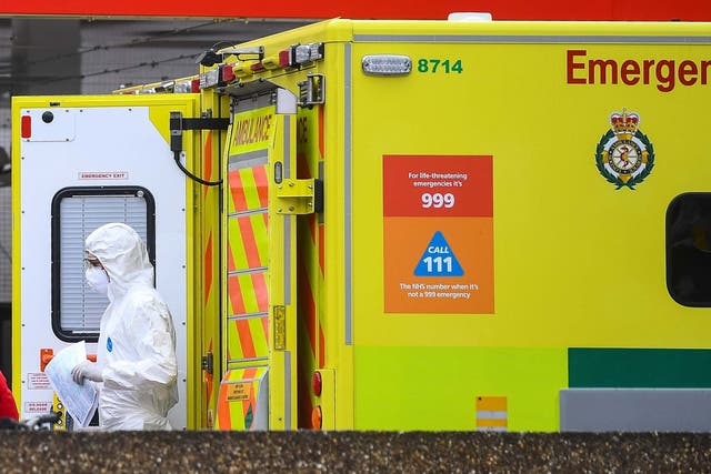 A paramedic wearing personal protective equipment (PPE) exits an ambulance outside St Thomas' Hospital in Westminster