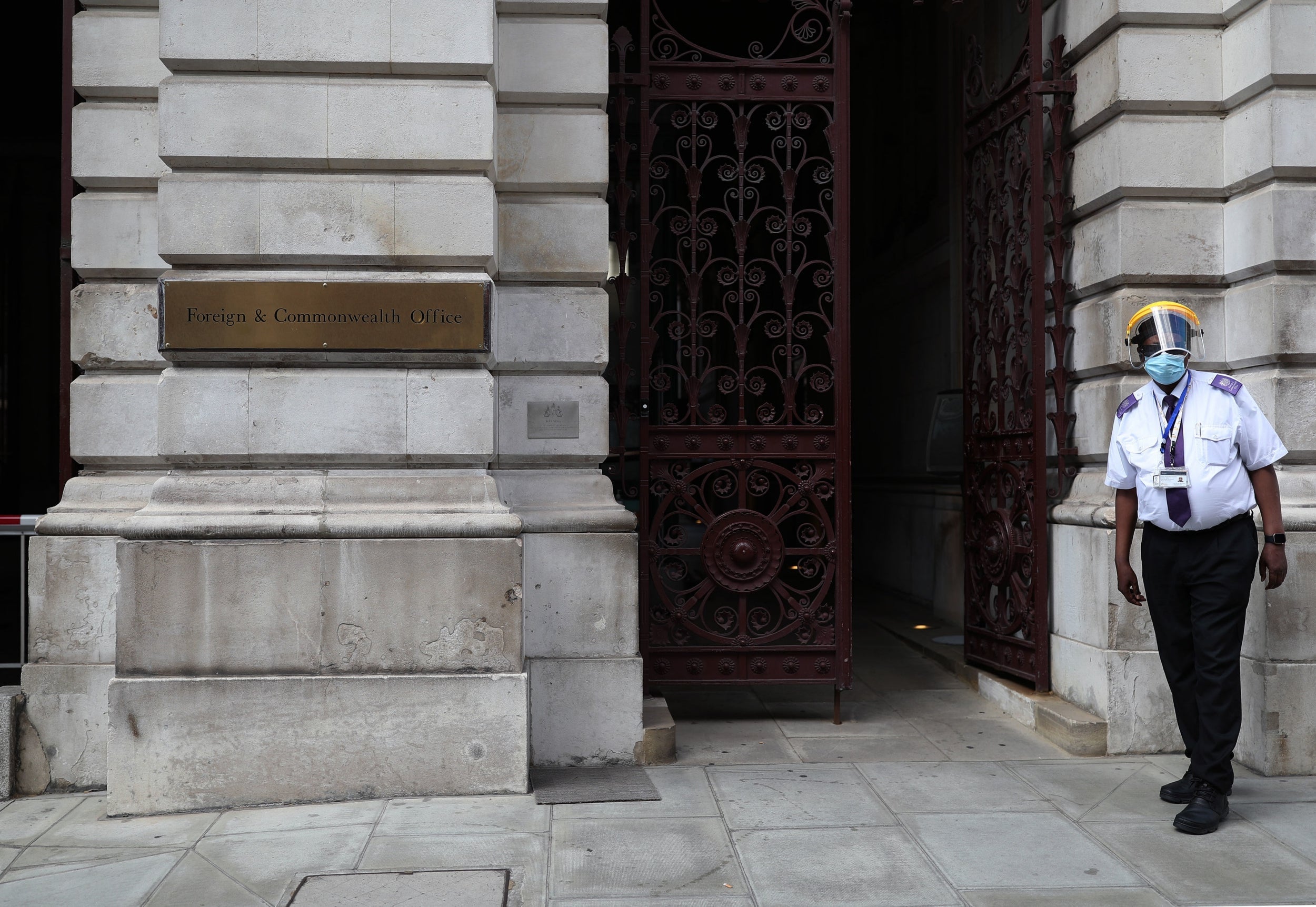 A guard in protective gear stands at the entrance of the Foreign Office