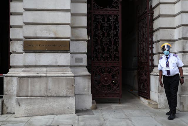 A guard in protective gear stands at the entrance of the Foreign Office