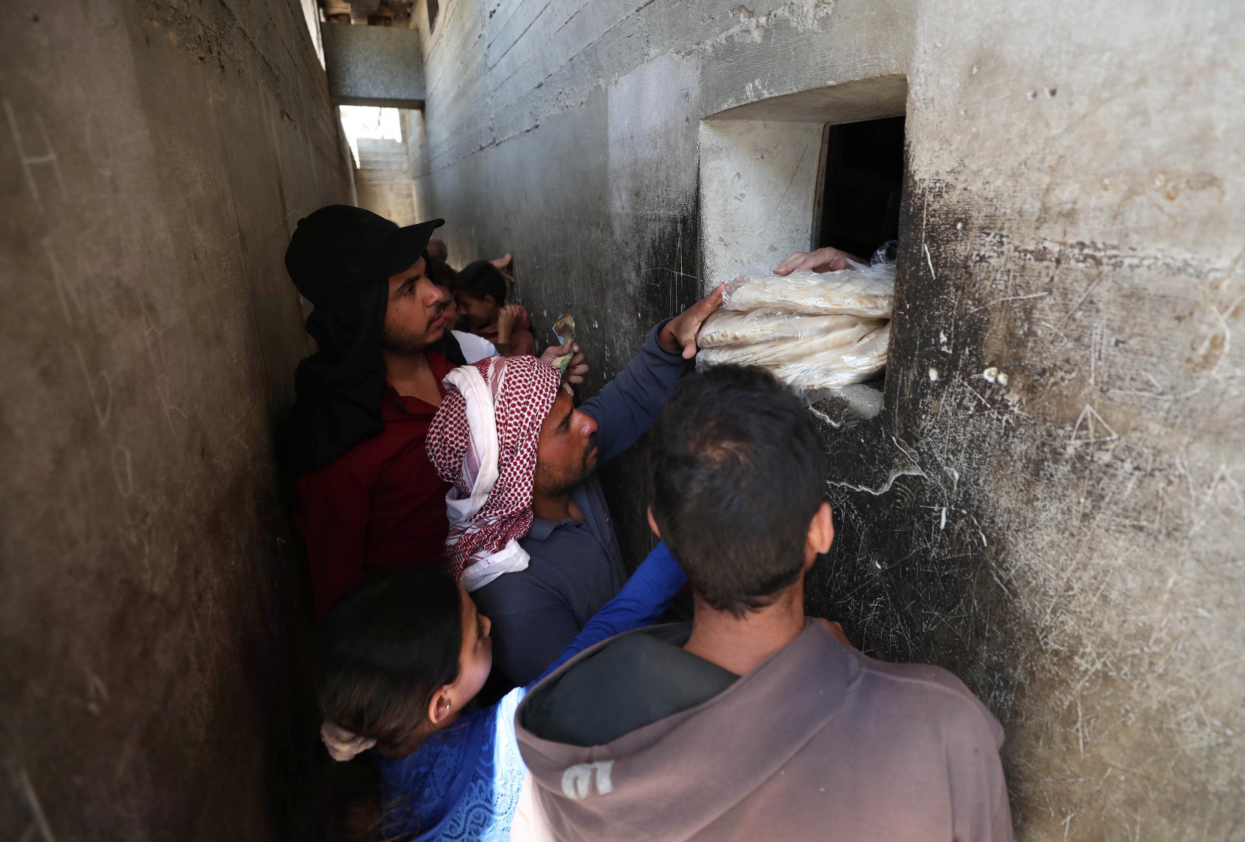 Syrians buy bread at a shop in the town of Binnish in the country's northwestern Idlib province on June 9, 2020 as Syrians held a third day of rare anti-regime protests over deteriorating living conditionsin the government-held city of Sweida