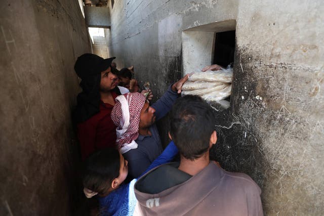 Syrians buy bread at a shop in the town of Binnish in the country's northwestern Idlib province on June 9, 2020 as Syrians held a third day of rare anti-regime protests over deteriorating living conditionsin the government-held city of Sweida