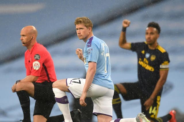 Manchester City's Kevin De Bruyne (C) and Arsenal's Pierre-Emerick Aubameyang take a knee