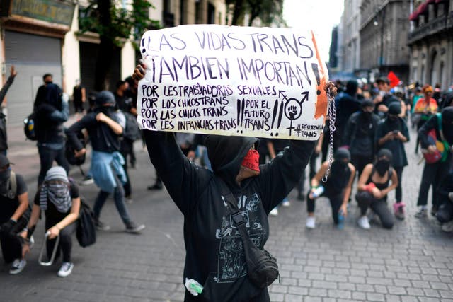 A demonstrator holds a sign supporting the transgender community during a protest against police brutality