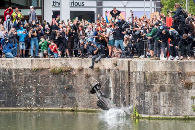 The statue of 17th-century slave trader Edward Colston is thrown into the harbour