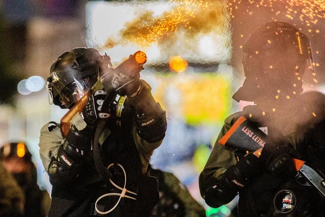 A member of the police police fires tear gas towards residents and protesters in the Causeway Bay area of Hong Kong on November 2, 2019