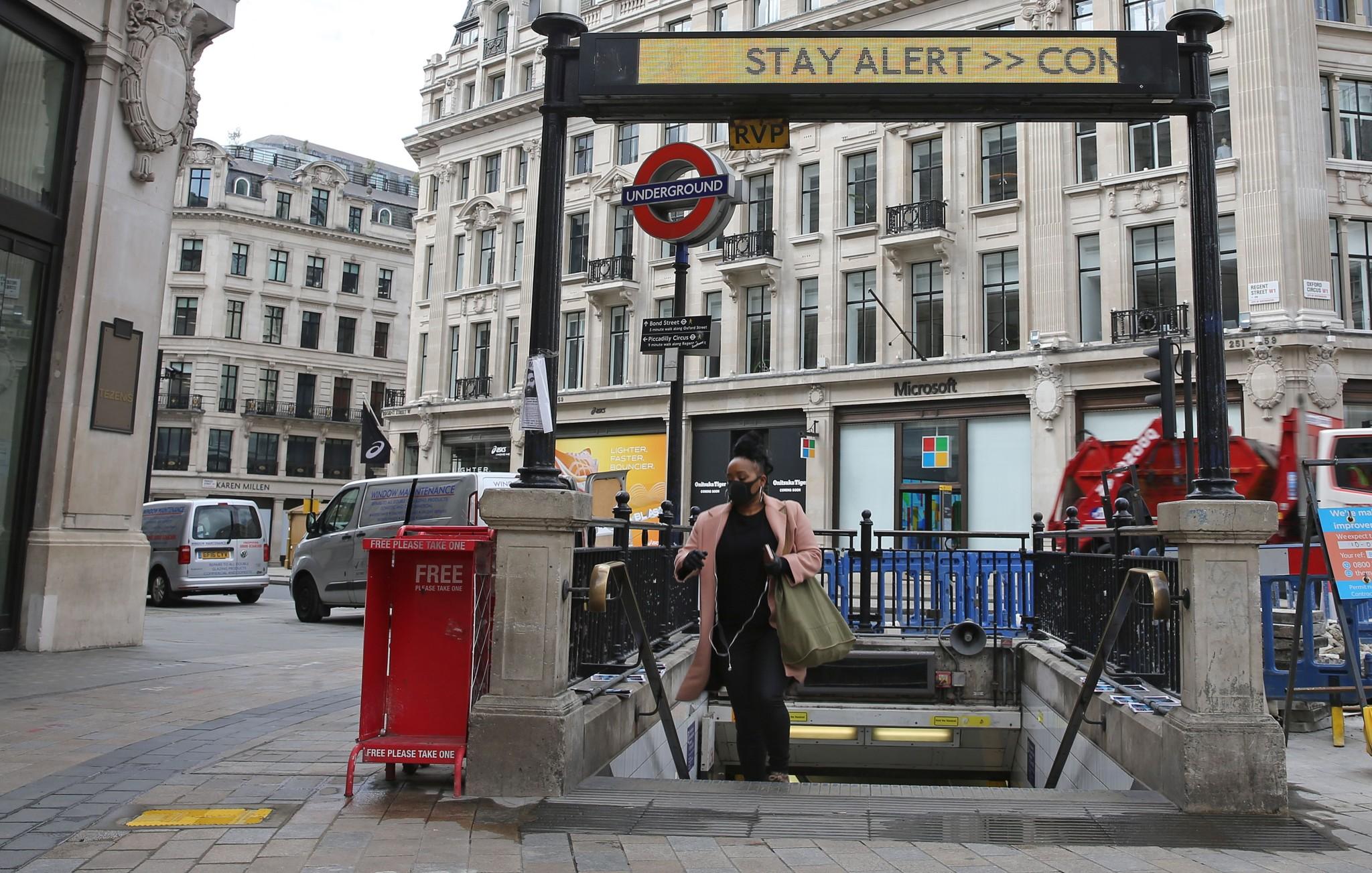 A commuter wearing PPE passes beneath the government’s slogan: ‘Stay Alert, Control the Virus, Save Lives’ above the exit to Oxford Circus Underground station in central London