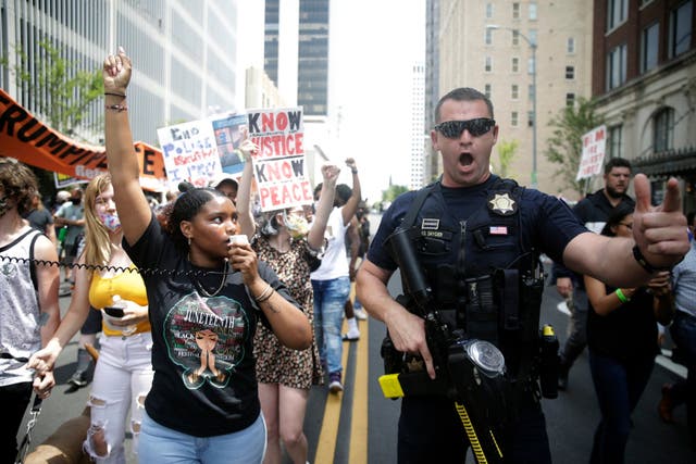 A police officer gestures during a Black Lives Matter event near the BOK Centre in Tulsa, Oklahoma ahead of a campaign rally by Donald Trump