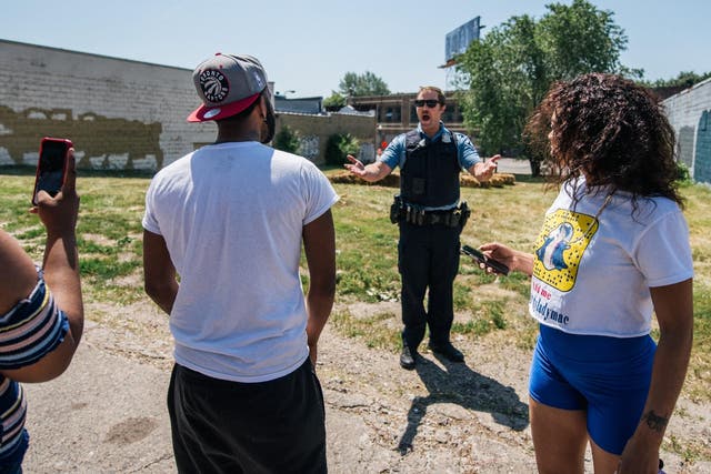 A man argues with a Minneapolis Police officer at a crime scene on 16 June in Minneapolis, following a new wave of anti-police protests across the US