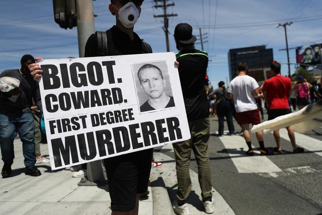 A protester holds a sign with a photo of former Minneapolis police officer Derek Chauvin during demonstrations following the death of George Floyd