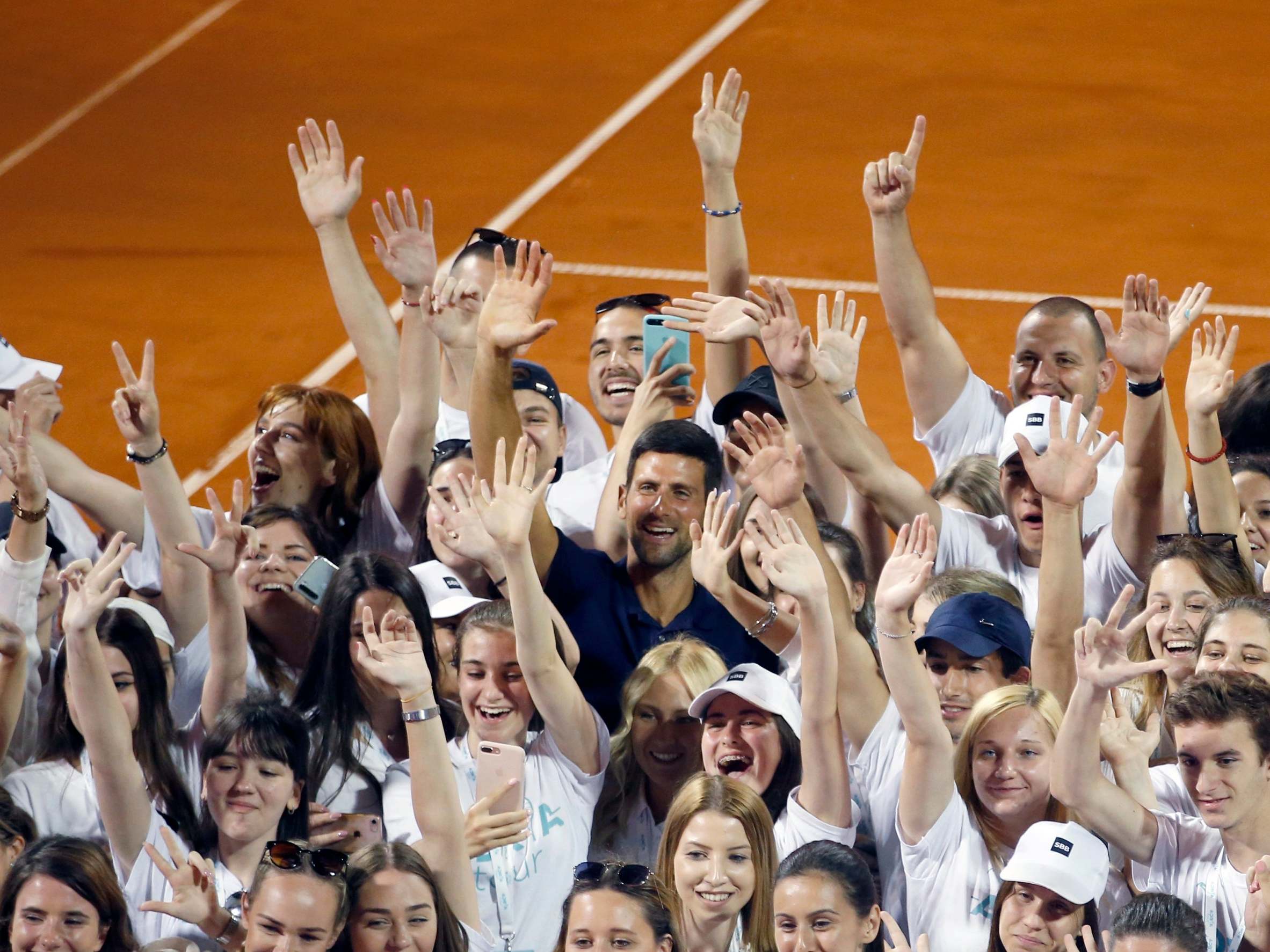 Novak Djokovic poses with a number of young volunteers and players on Sunday 14 June in Belgrade