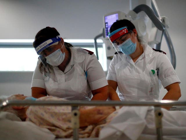 Radiologists wearing visors and masks comfort a patient before an x-ray. While the NHS has weathered the first outbreak of coronavirus a second wave this winter could prove far more difficult to handle