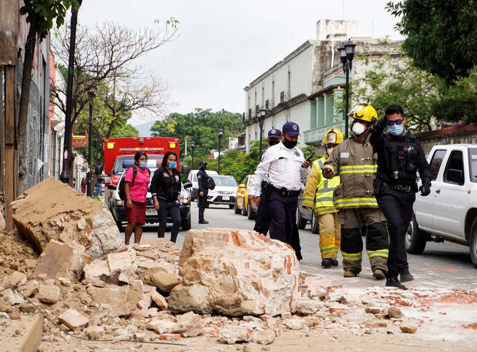 Members of the police and fire department observe the damage caused by a collapsed wall in Oaxaca, Mexico, 23 June 2020