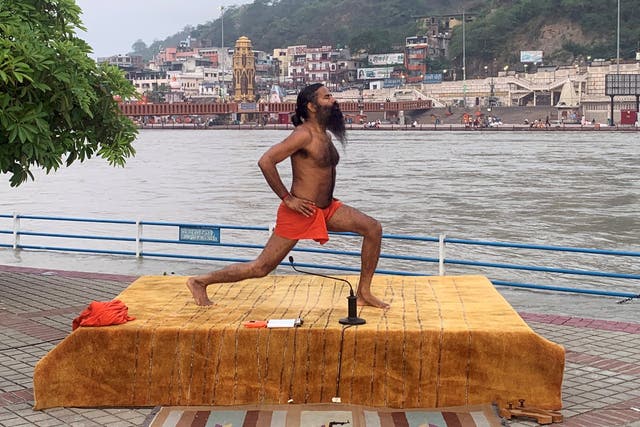 India's yoga guru Baba Ramdev performing yoga on the banks of the river Ganges ahead of International Yoga day, in the northern town of Haridwar, India, on 19 June