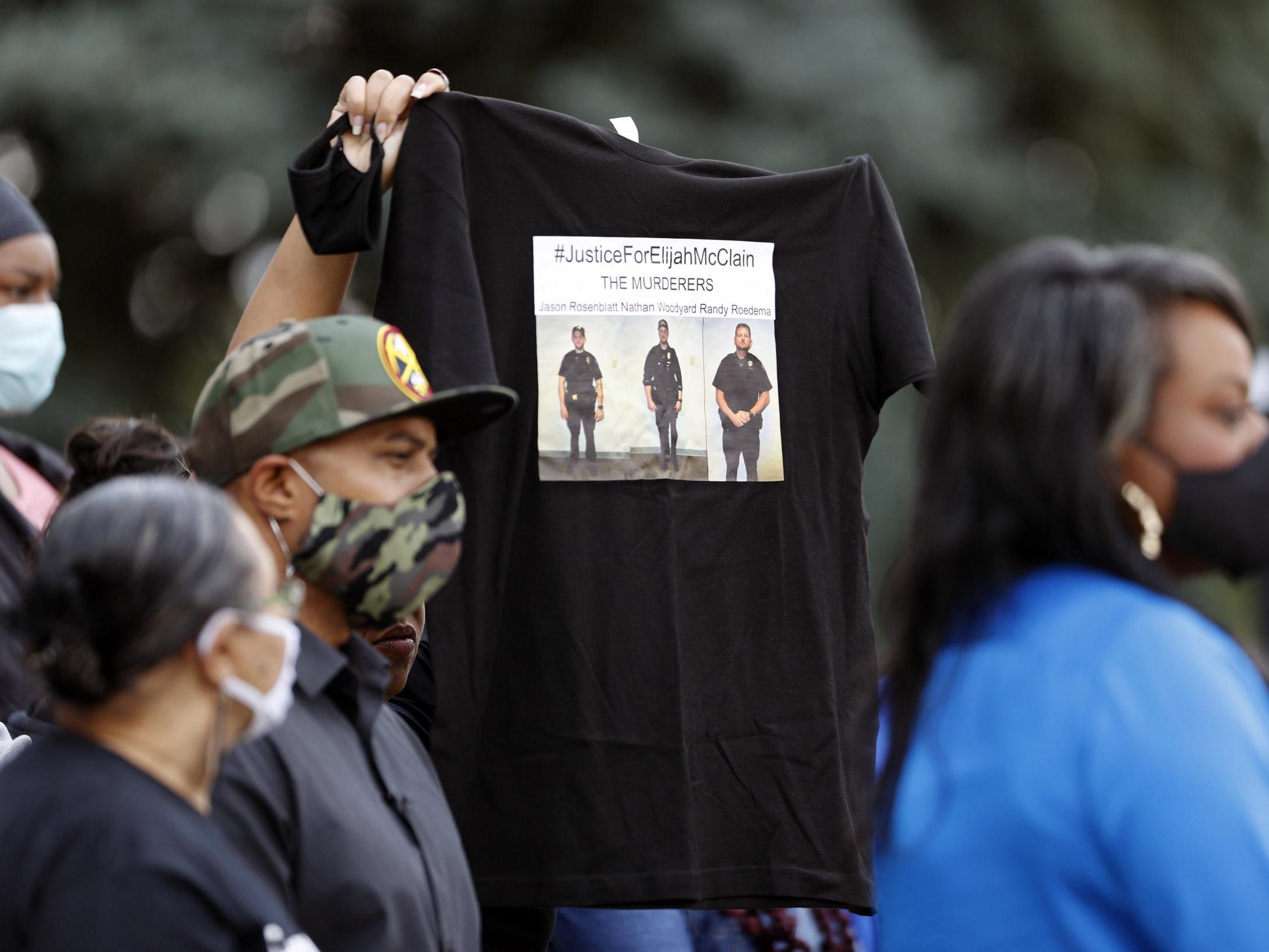 A supporter holds up a shirt to call attention to the death of Elijah McClain in August 2019 in Aurora, Colorado during a news conference on the steps of the State Capitol