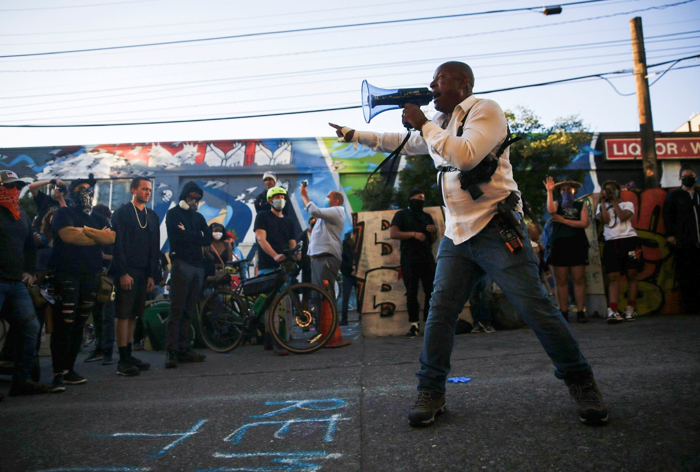 Community response team member Harry Hearns addresses protesters outside the police department