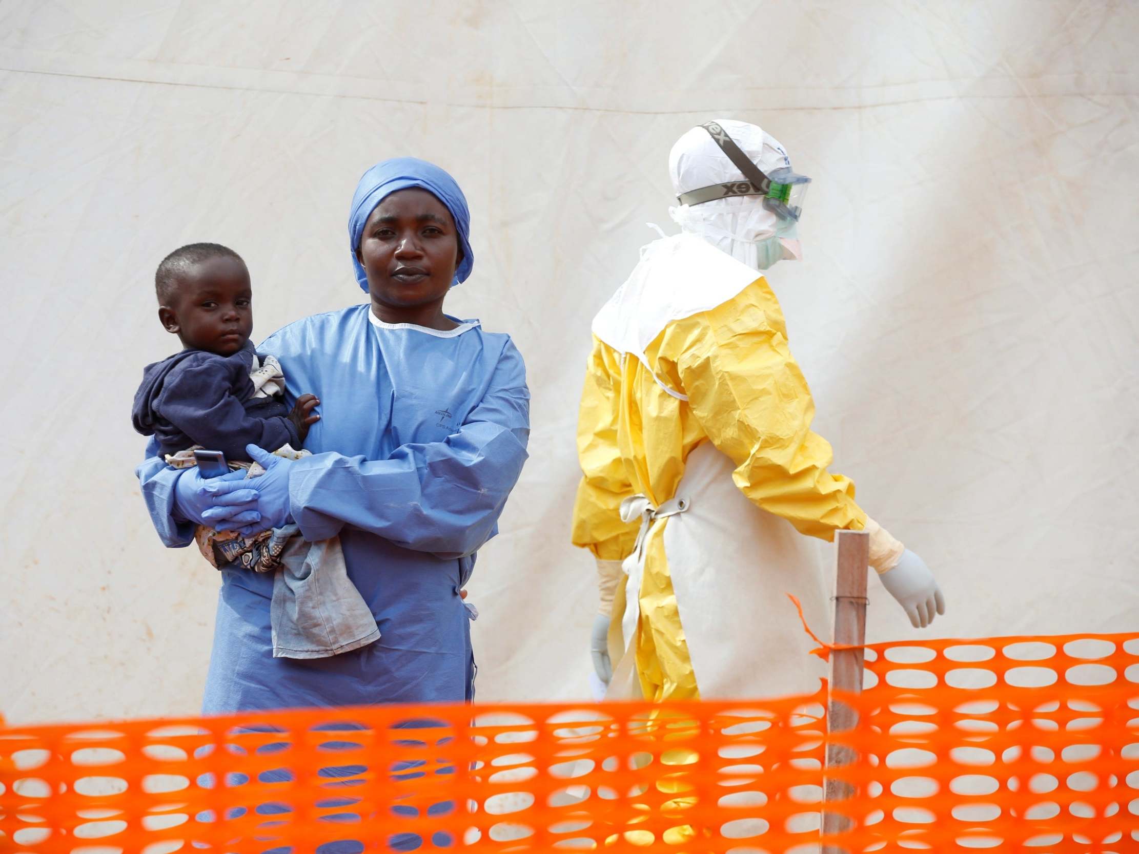 Mwamini Kahindo, an Ebola survivor, holds an infant outside the red zone at the treatment centre in Butembo, Democratic Republic of Congo