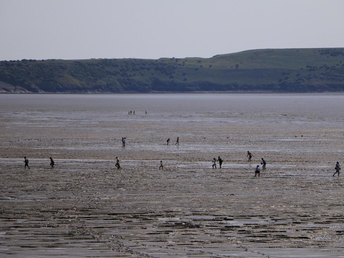 Beachgoers get stuck in mud flats attempting to reach the sea in Weston-super-Mare