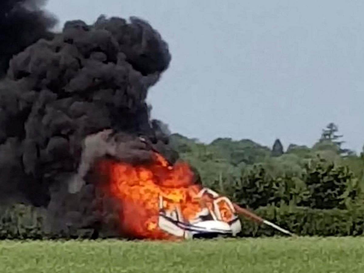 Helicopter bursts into flames after crash-landing in field by pub in