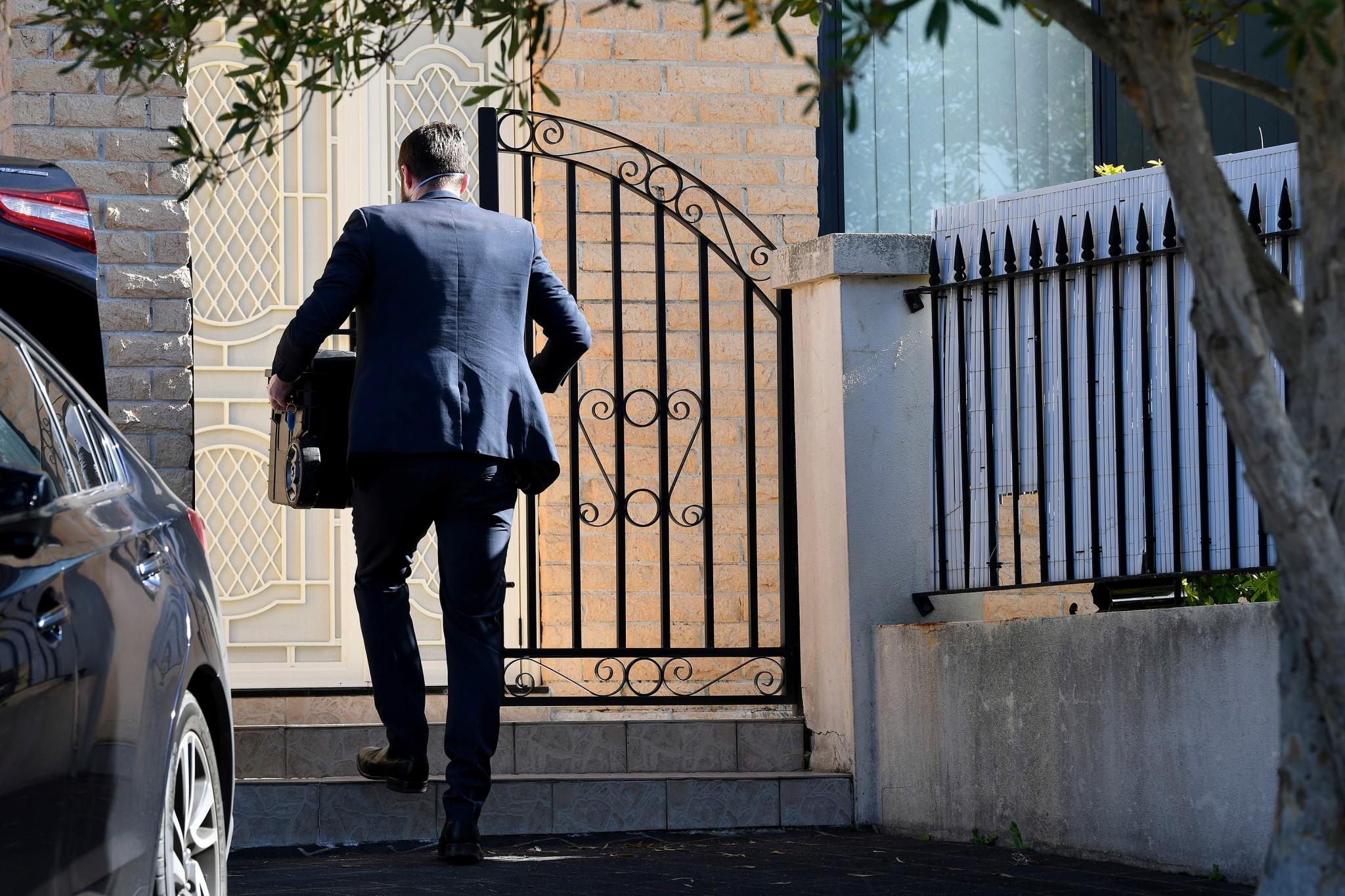 A federal officer enters the home of New South Wales state MP Shaoquett Moselmane in Sydney on Friday after he was suspended from his party and his home was searched in an investigation of alleged influence by China