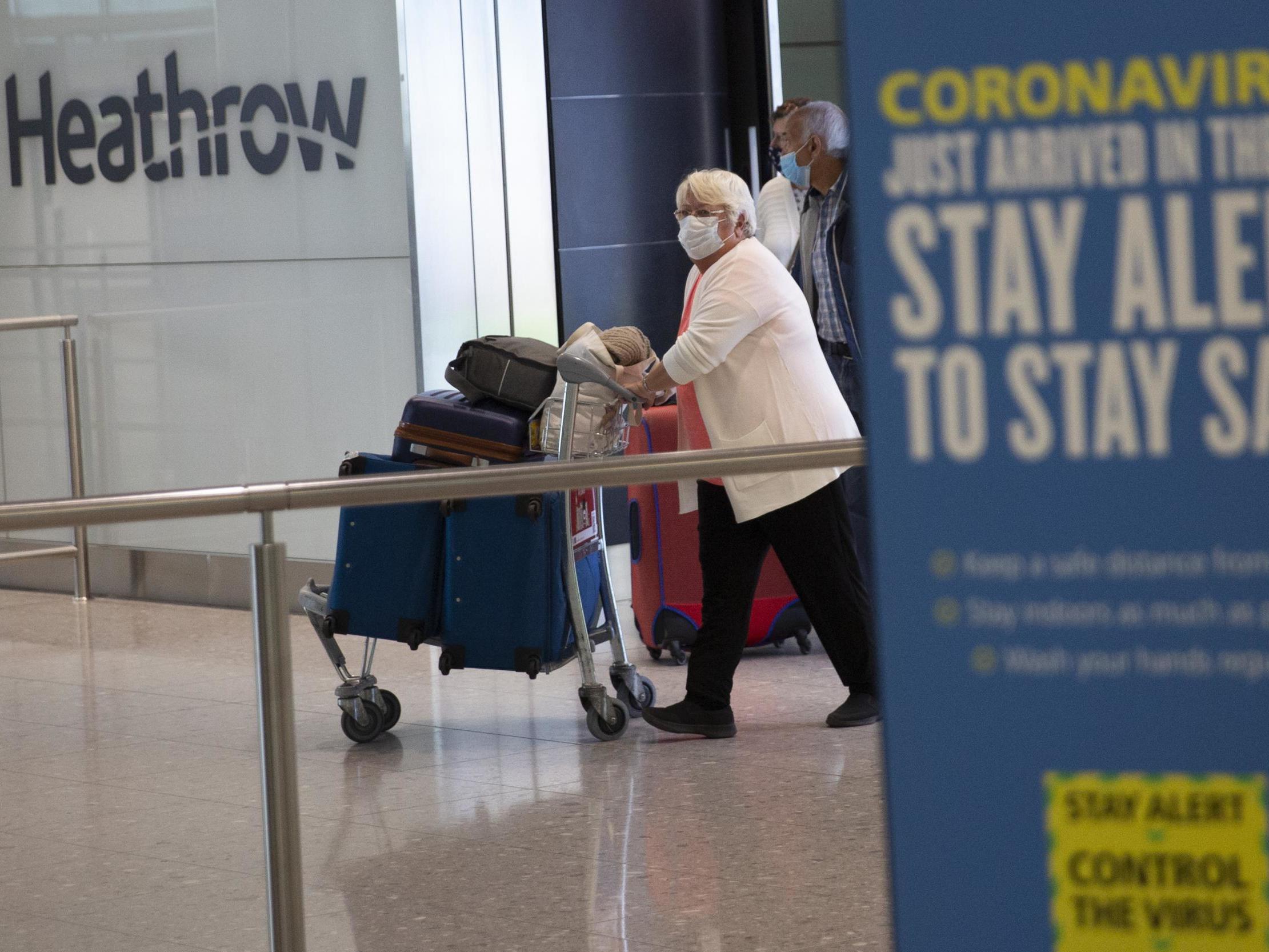 Passengers arrive at Heathrow on the first day of the 14-day quarantine policy