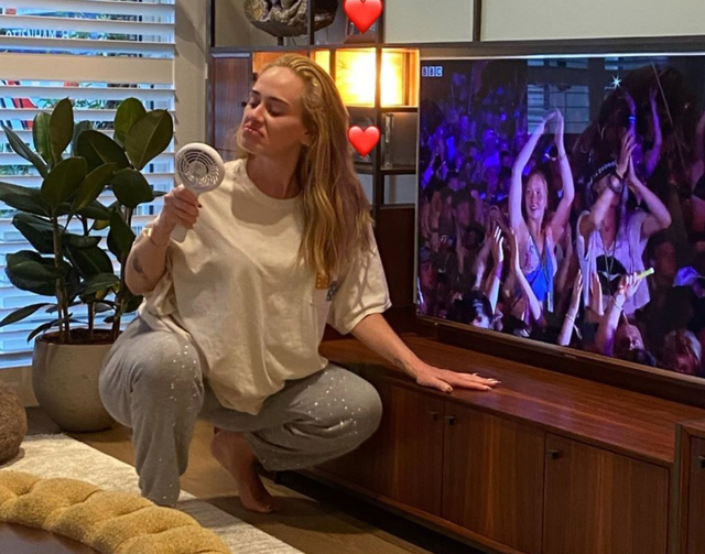 Adele poses in front of the TV as she watches her 2016 Glastonbury performance