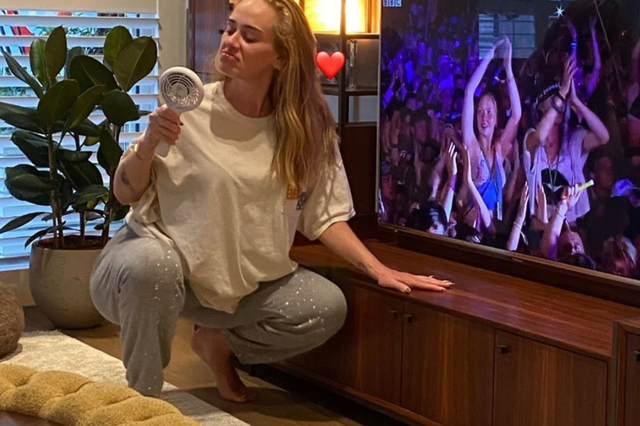 Adele poses in front of the TV as she watches her 2016 Glastonbury performance