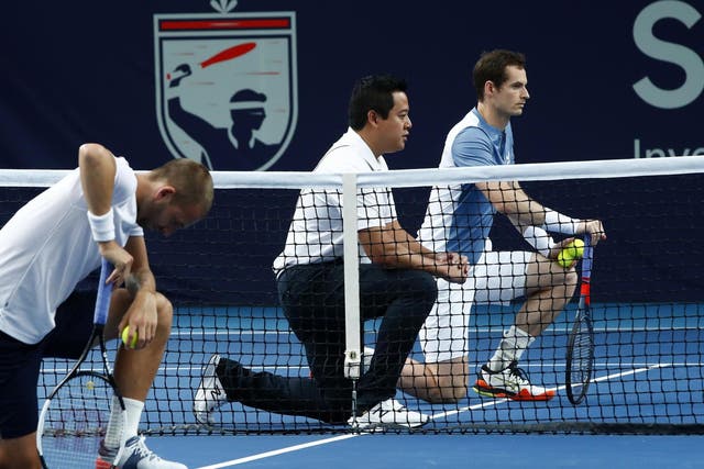 Andy Murray (right) takes a knee alongside opponent Dan Evans and umpire James Keothavong
