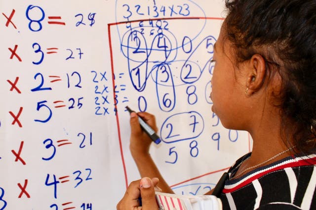 In Colombia, Maria, 8 years-old, from Venezuela, works on maths problems