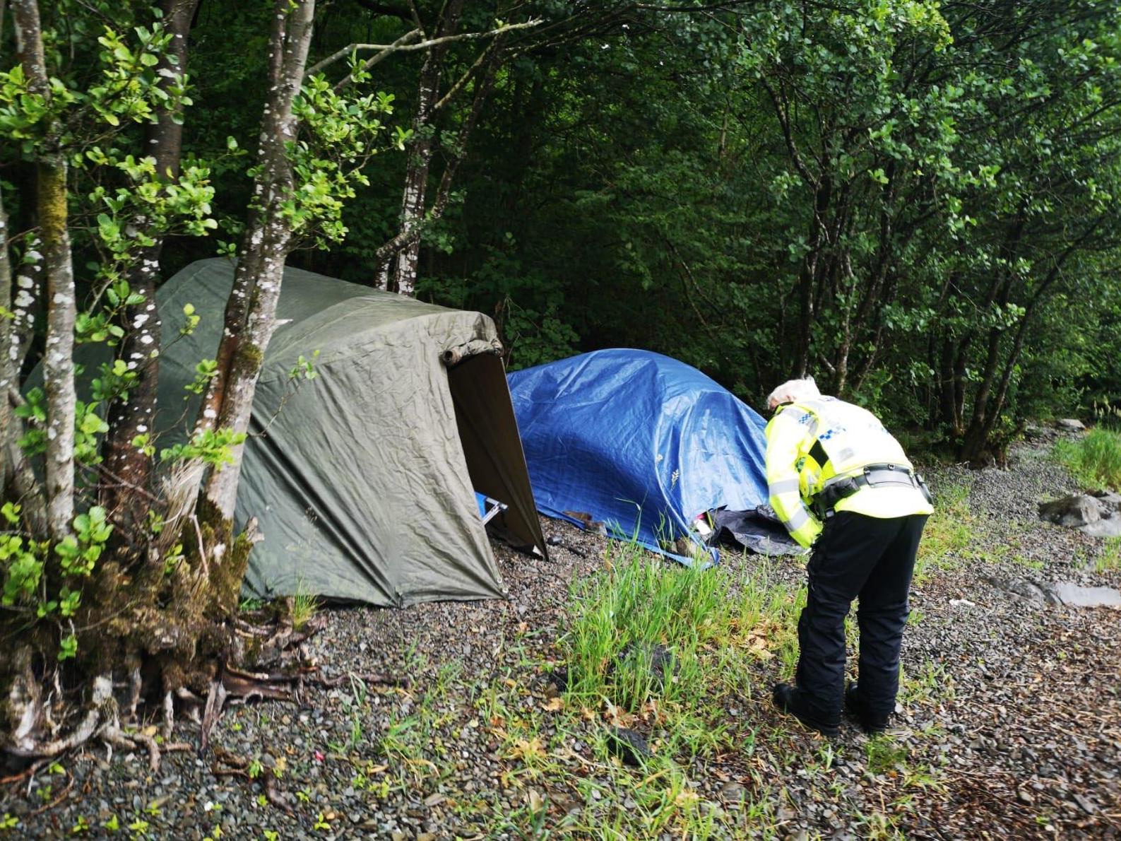An officer speaks to people illegally camping in the Lake District. Overnight stays are not yet allowed until coronavirus lockdown measures ease further on 4 July