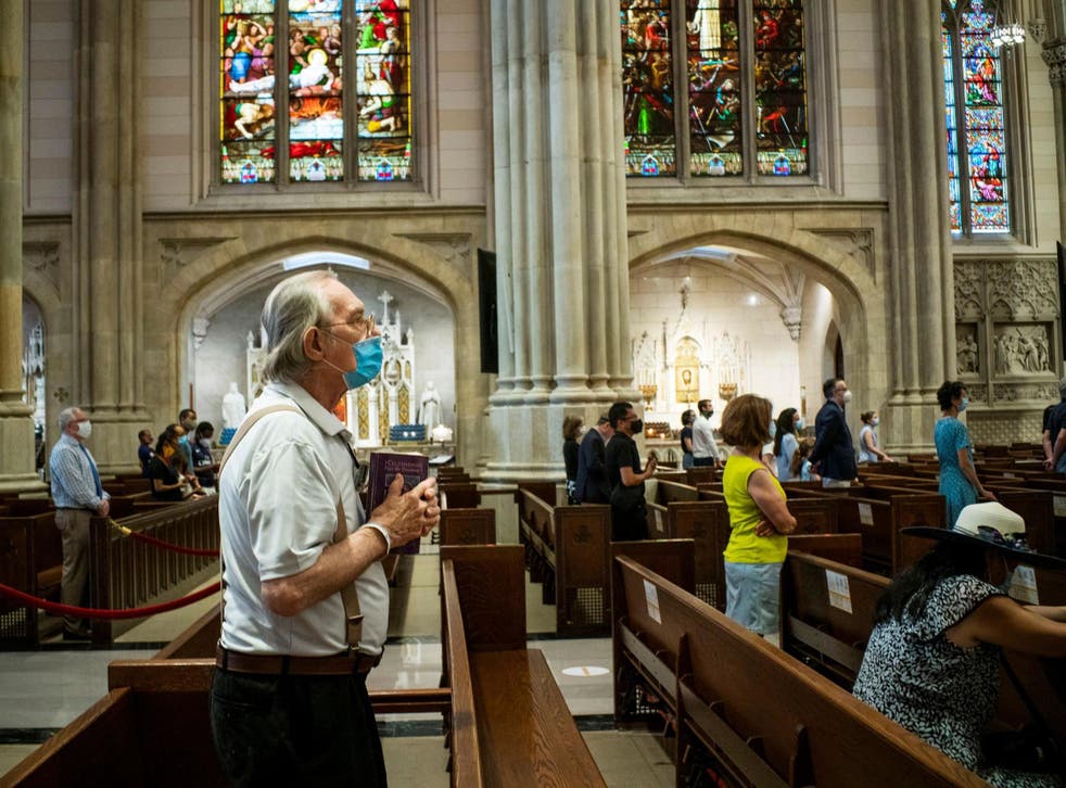 People listen to Cardinal Timothy Dolan as he celebrates a mass at St. Patrick's Cathedral in New York on 28 June. The US has the highest of any national death toll worldwide.