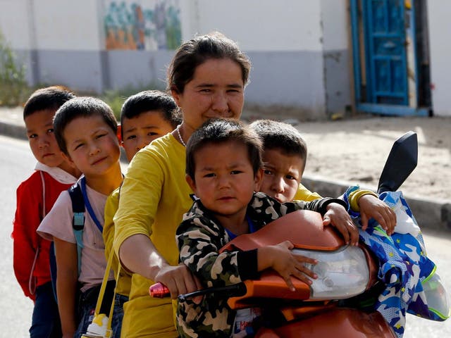 A Uighur woman with her children at the Unity New Village in western China's Xinjiang region